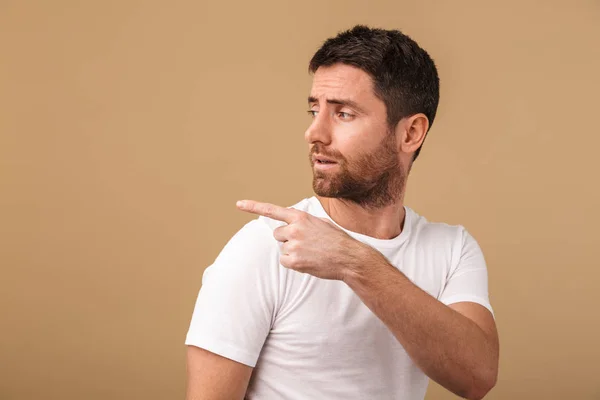 Portrait Upset Young Man Casually Dressed Standing Isolated Beige Pointing — Stock Photo, Image