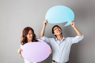 Boş konuşma balonu holding, gri arka plan üzerinde izole ayakta Asya Çift