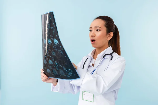 Fotografie Lékaře Šokovaná Dívka Pózuje Izolované Modré Zdi Pozadí Ray — Stock fotografie