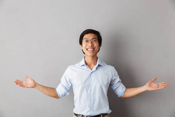 Happy Asian Man Standing Isolated Gray Background Outsretched Hands — Stock Photo, Image