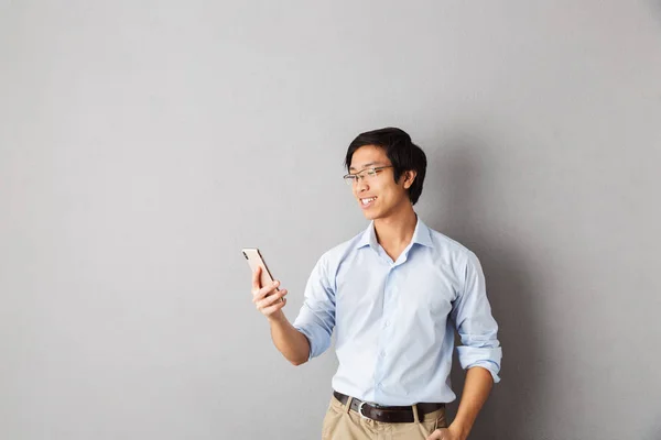 Gelukkig Aziatische Zakenman Grijze Achtergrond Geïsoleerd Staande Houden Van Mobiele — Stockfoto