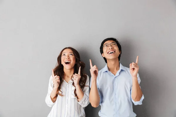 陽気なアジア ビジネスのカップルは分離灰色の背景の上に立ってで指を指してコピー スペース — ストック写真