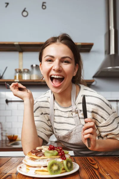 キッチンの料理の美しい若い女性のイメージのケーキを食べると — ストック写真