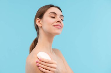 Sabun tutan mavi arka plan üzerinde izole fotoğraf güzel mutlu genç kadının poz.