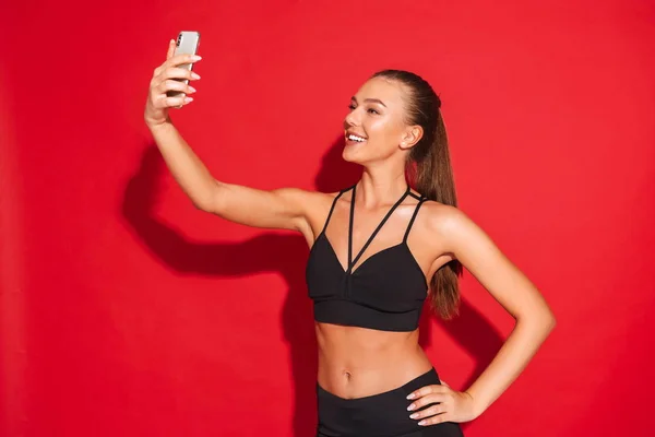 Retrato Una Joven Deportista Forma Sobre Fondo Rojo Tomando Una — Foto de Stock