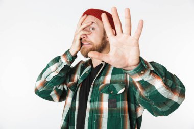 Şapka ve çığlık ve beyaz arka plan üzerinde izole ayakta iken kafa kapma kareli gömlek giyen mutsuz adam portresi