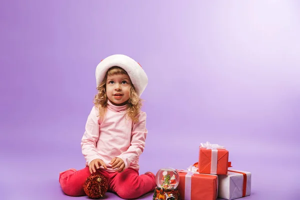 Веселая Маленькая Девочка Празднует Рождество Подарками Изолированы Фиолетовом Фоне — стоковое фото
