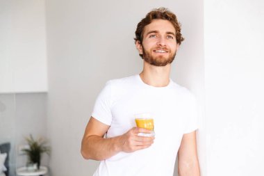 Yakışıklı bir genç sakallı adam görüntüsünü evde suyu içme.