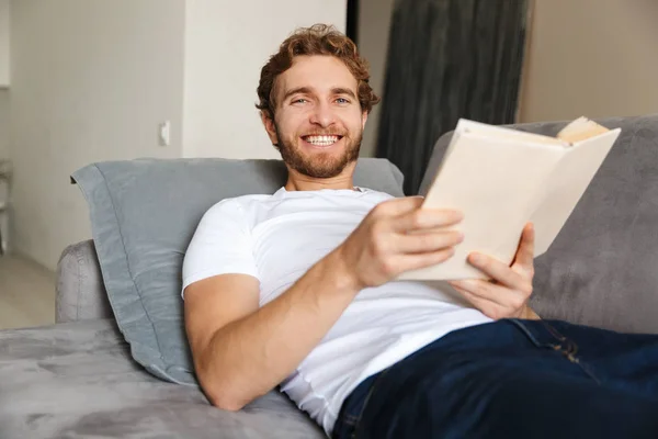 Immagine Bel Giovane Barbuto Sul Divano Casa Leggere Libro — Foto Stock