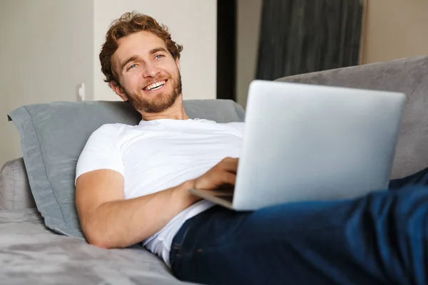 Bilden Stilig Ung Skäggig Man Soffan Använder Hemma Bärbar Dator — Stockfoto