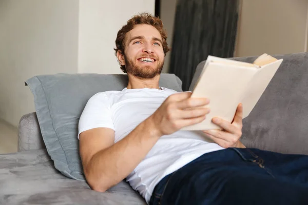 Immagine Bel Giovane Barbuto Sul Divano Casa Leggere Libro — Foto Stock