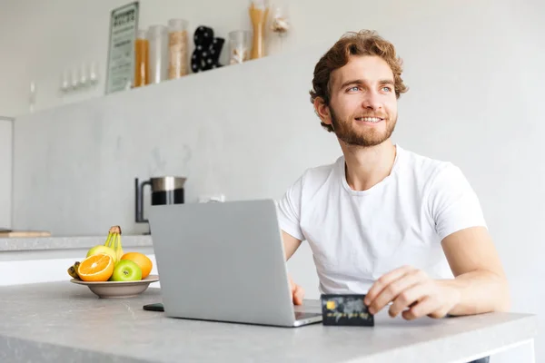 Foto Joven Barbudo Feliz Mesa Casa Hablando Con Ordenador Portátil —  Fotos de Stock