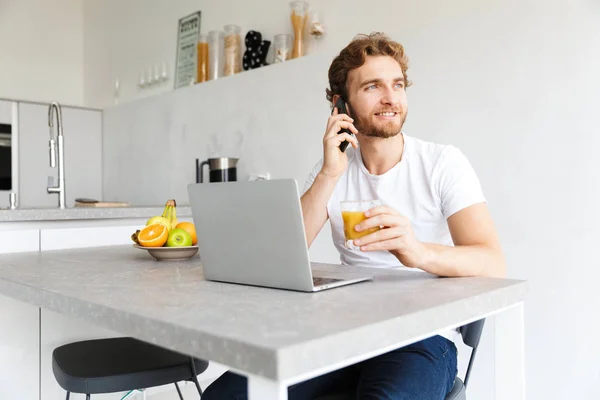 Foto Joven Barbudo Feliz Mesa Casa Hablando Con Ordenador Portátil —  Fotos de Stock