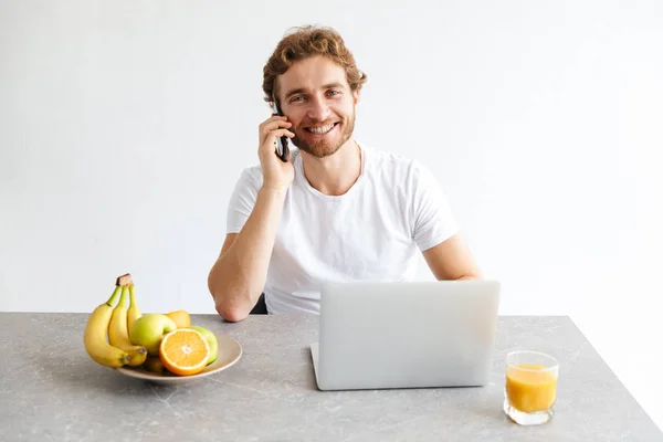 Foto Joven Barbudo Feliz Mesa Casa Hablando Con Ordenador Portátil —  Fotos de Stock