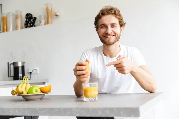 Foto Lycklig Ung Skäggige Mannen Vid Bordet Hemma Göra Juice — Stockfoto