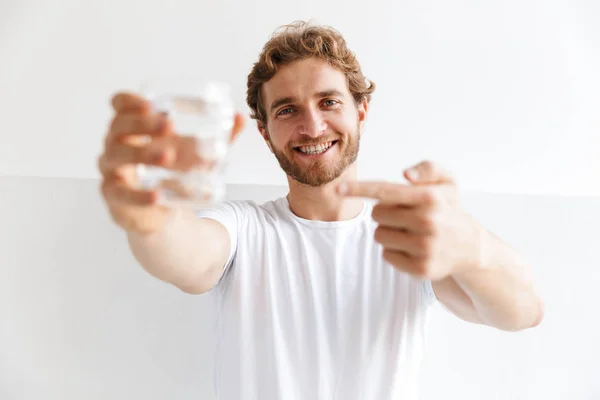 Smiling Young Man Showing Glass Water Standing Wall Home — Stock Photo, Image