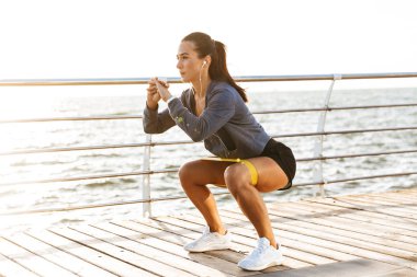 Plajda bir lastik bant egzersizleri yapıyor sporcumuz konsantre