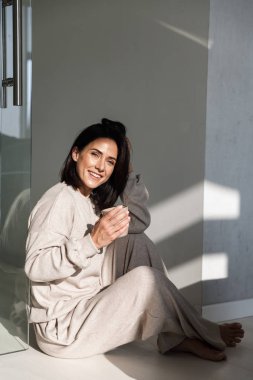 Güzel genç kadın yatak sitttng sırasında kahve içme