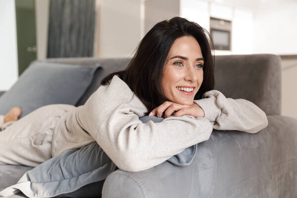 Beautiful young woman relaxing on a couch at home