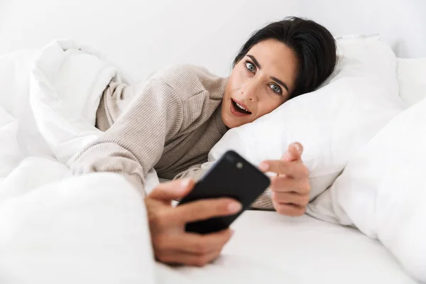 Zdjęcie Urocza Kobieta 30S Przy Użyciu Smartfona Podczas Leżenia Łóżku — Zdjęcie stockowe