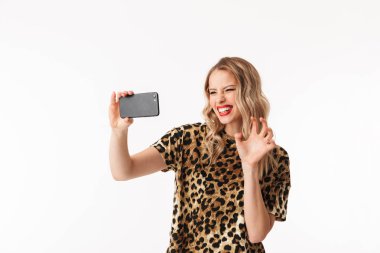 Bir selfie alarak beyaz arka plan üzerinde izole ayakta çekici bir genç sarışın kadın portresi