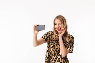 Bir selfie alarak beyaz arka plan üzerinde izole ayakta çekici bir genç sarışın kadın portresi