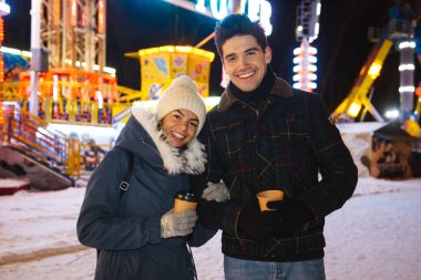 Buz pateni parkta geceleri, paket servisi olan restoran kahve tutan eğleniyor mutlu genç Çift