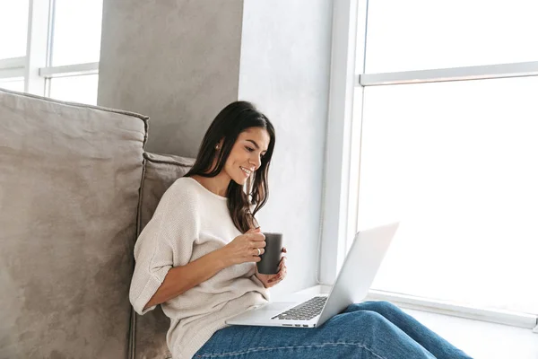 Smiling Young Woman Using Laptop Computer While Sitting Floor Couch — Stock Photo, Image