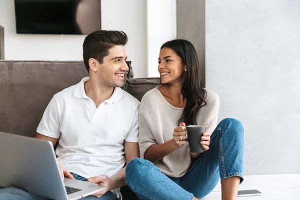 Pareja Joven Feliz Sentada Piso Casa Usando Ordenador Portátil —  Fotos de Stock