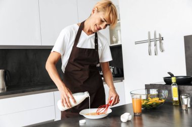 Çekici kadın evde mutfak at dururken yemek pişirme