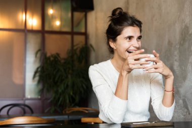 İçeride kahve içme kafede oturan güzel genç kadın görüntüsünü.