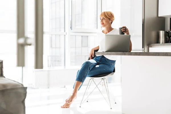 Lächelnde Frau Lässig Mit Laptop Gekleidet Während Sie Der Küche — Stockfoto