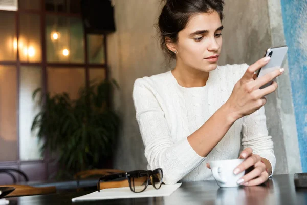 Foto Una Joven Bastante Seria Sentada Cafetería Bebiendo Café Interior — Foto de Stock