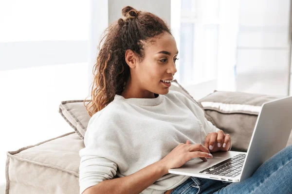 Foto Van Schattige African American Vrouw Met Laptop Liggend Bank — Stockfoto