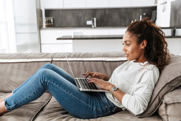 Foto Avslappnad Afroamerikanska Kvinna Använder Laptop Liggandes Soffan Ljust Vardagsrum — Stockfoto