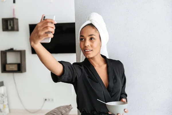 Muotokuva Onnellinen Afrikkalainen Amerikkalainen Nainen Yllään Housecoat Ottaa Selfie Matkapuhelimeen — kuvapankkivalokuva