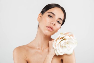 Bir çiçek ile poz beyaz arka plan üzerinde izole duran bir çekici şehvetli sağlıklı kadın Güzellik Portresi