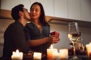 Evde mum ışığında romantik bir akşam yemeği, öpüşme güzel tutkulu Çift