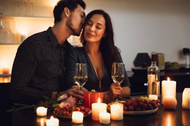 Evde mum ışığında romantik bir akşam yemeği, öpüşme güzel tutkulu Çift