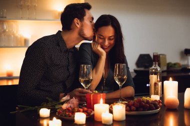 Evde mum ışığında romantik bir akşam yemeği, öpüşme güzel tutkulu Çift