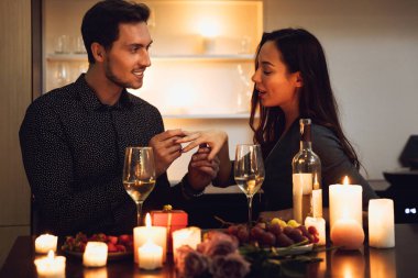 Evde, bir mum ışığında romantik akşam yemeği güzel tutkulu çift bir teklif yapma adam
