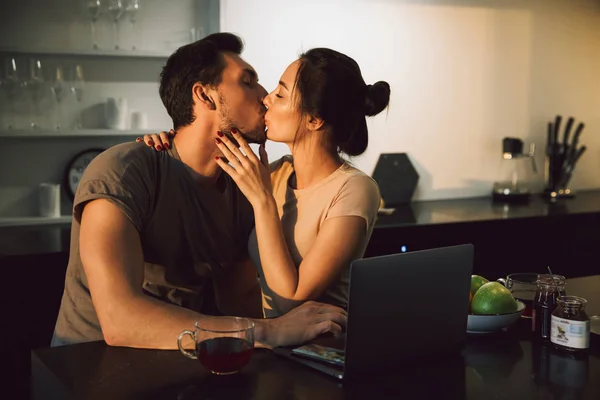 Mooie Jonge Paar Omarmen Zittend Aan Keukentafel Met Laptop — Stockfoto