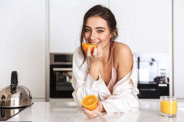 Kafkas kadın mutfakta ipek eğlence giyim holding iki adet turuncu giymiş 20s görüntüsünü