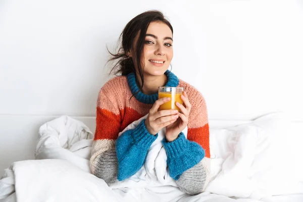 Foto Van Brunette Vrouw 20S Liggend Bed Thuis Drinken Sinaasappelsap — Stockfoto