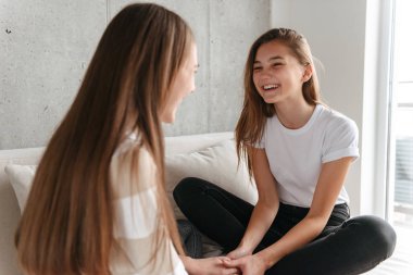 Evde otururken konuşurken iki neşeli kız