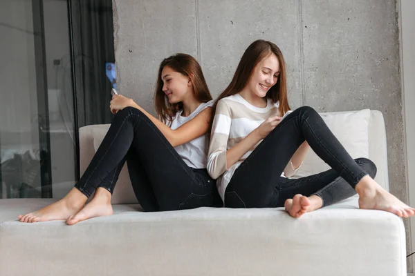携帯電話を使用して 2 つの美しい若い 10 代の女の子 — ストック写真