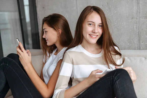 携帯電話を使用して 2 つの美しい若い 10 代の女の子 — ストック写真