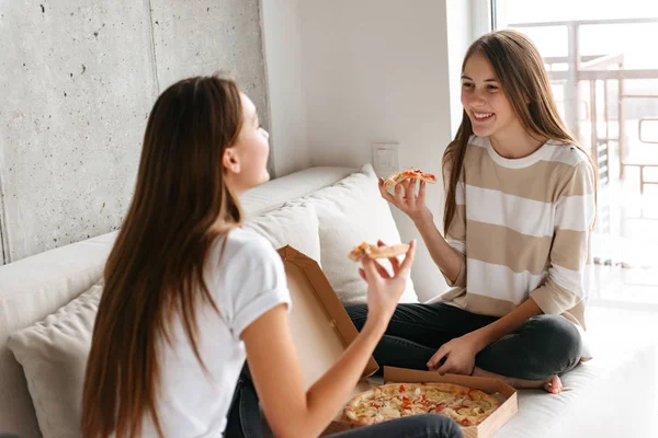 Две веселые девочки-подростки разговаривают, сидя — стоковое фото