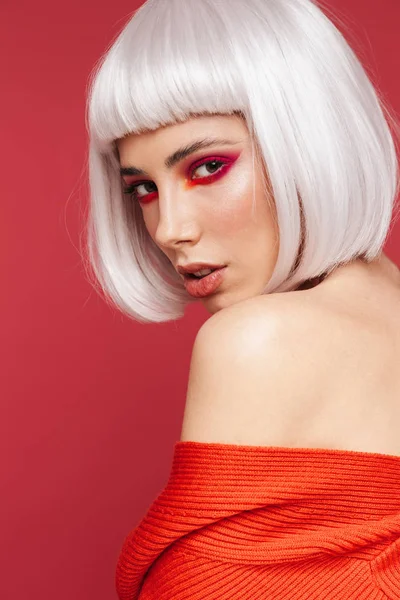 Beautiful young woman isolated over red wall background with bright makeup posing. — Stock Photo, Image