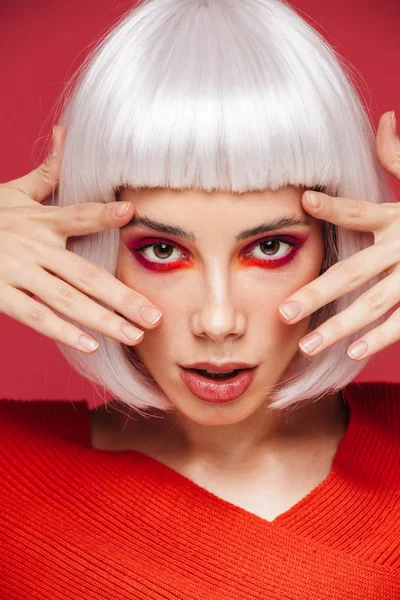 Bela jovem mulher isolado sobre vermelho parede fundo com brilhante maquiagem posando . — Fotografia de Stock